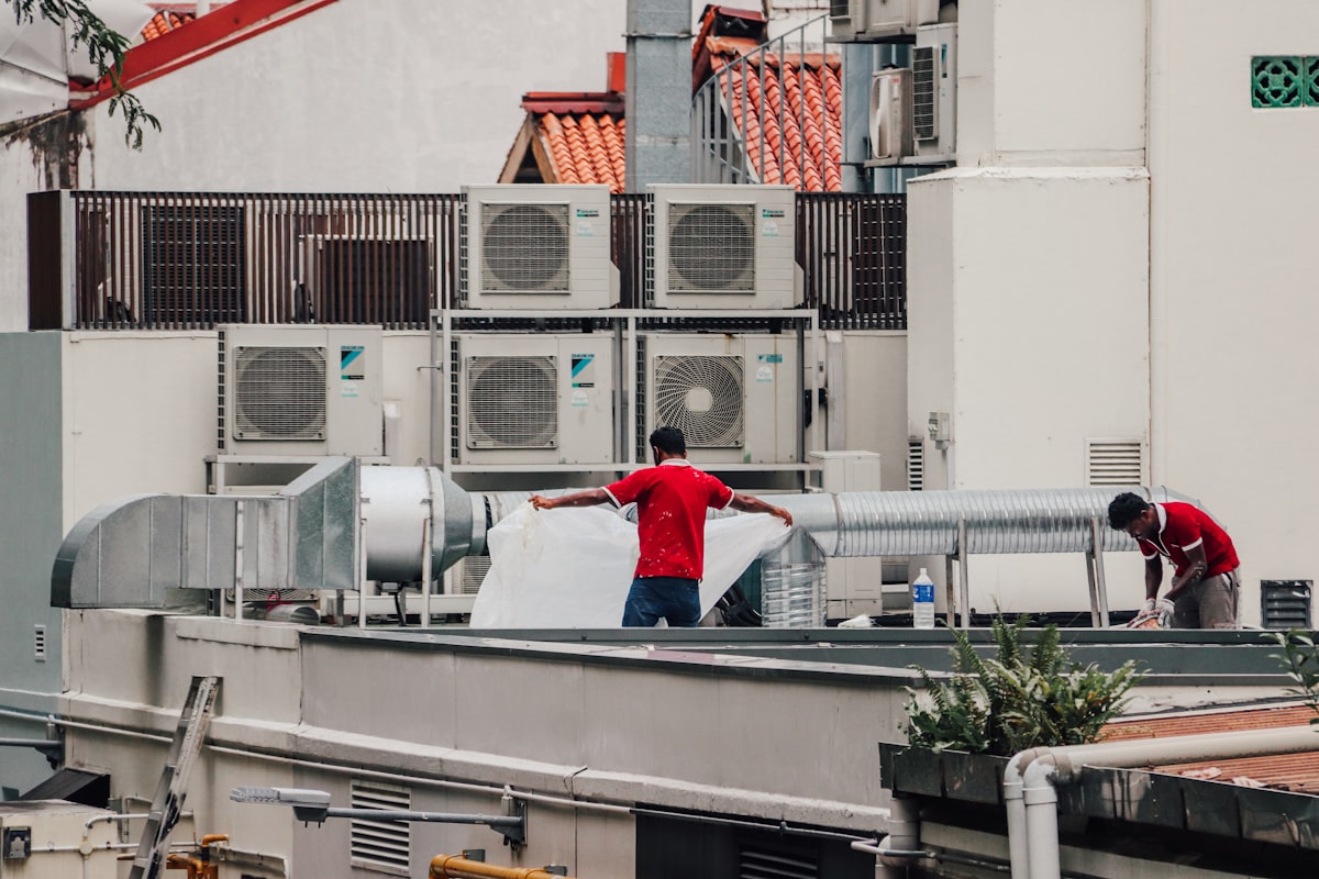 Technicians servicing commercial rooftop air conditioning units